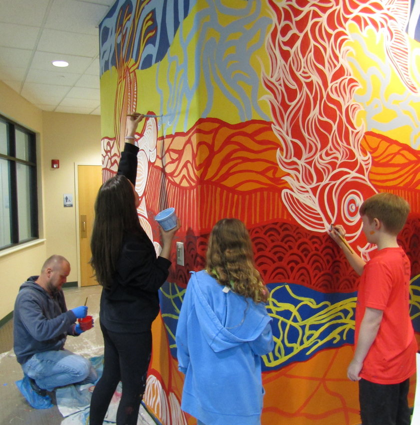 Professional muralist Daniel Crosier and middle school students work on a mural inside Buchanan Park Recreation Center.